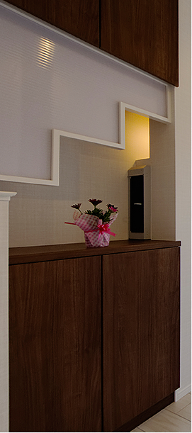 晩は白石オリジナルのお洒落で便利な玄関収納、水に強い大理石の飾り棚（ニッチ）のあるアクセントクロス、足元を照らす階段など美しく照らす多彩な間接照明で、暖かい雰囲気を演出。