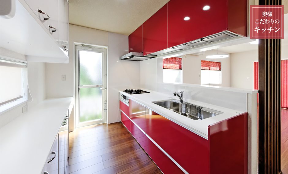 奥様こだわりの赤いカラーが印象的なクリナップの乾燥機付きシステムキッチン。