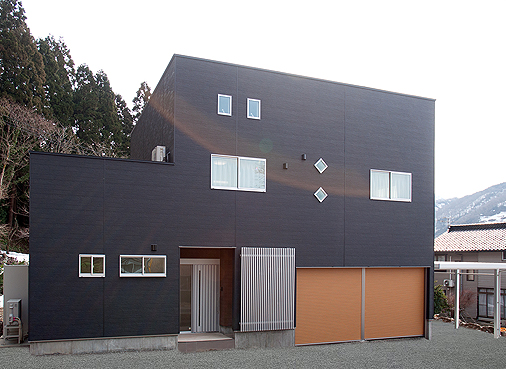 高級感のあるウッド調のシャッター、黒とシルバーのキューブ型の外観